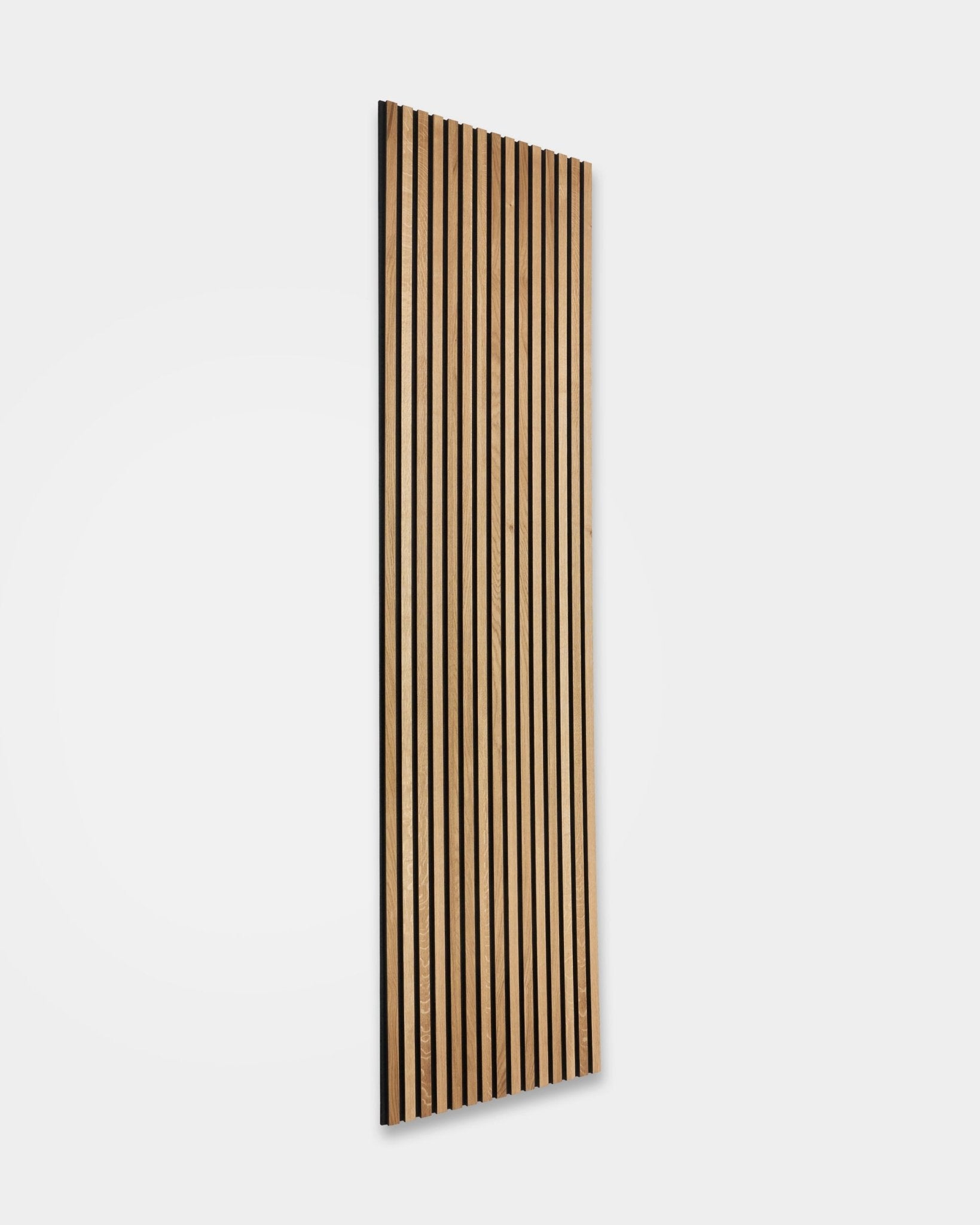 WoodUpp Akupanel Rustic in Brown Oak (240 x 60 cm) met vertical houten latten en donkere akoestische tussenruimtes, gemonteerd op een strakke witte muur voor Scandinavische geluidsdemping.
