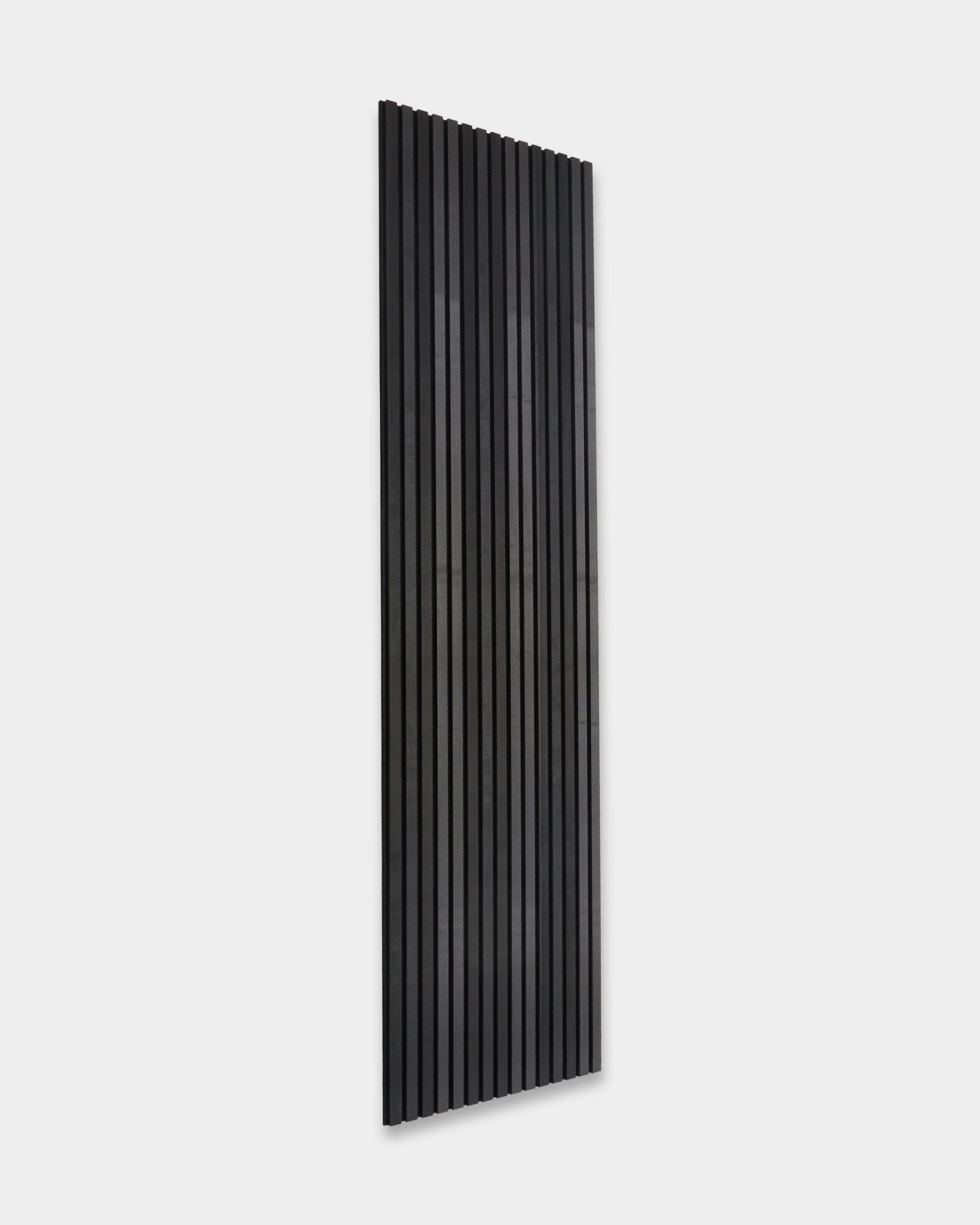 WoodUpp Akupanel Tonal Akoestisch paneel in Black Ash (300x60cm) met vertical latten, gemonteerd op een effen lichtgrijze muur, in een minimalistische Scandinavische stijl.