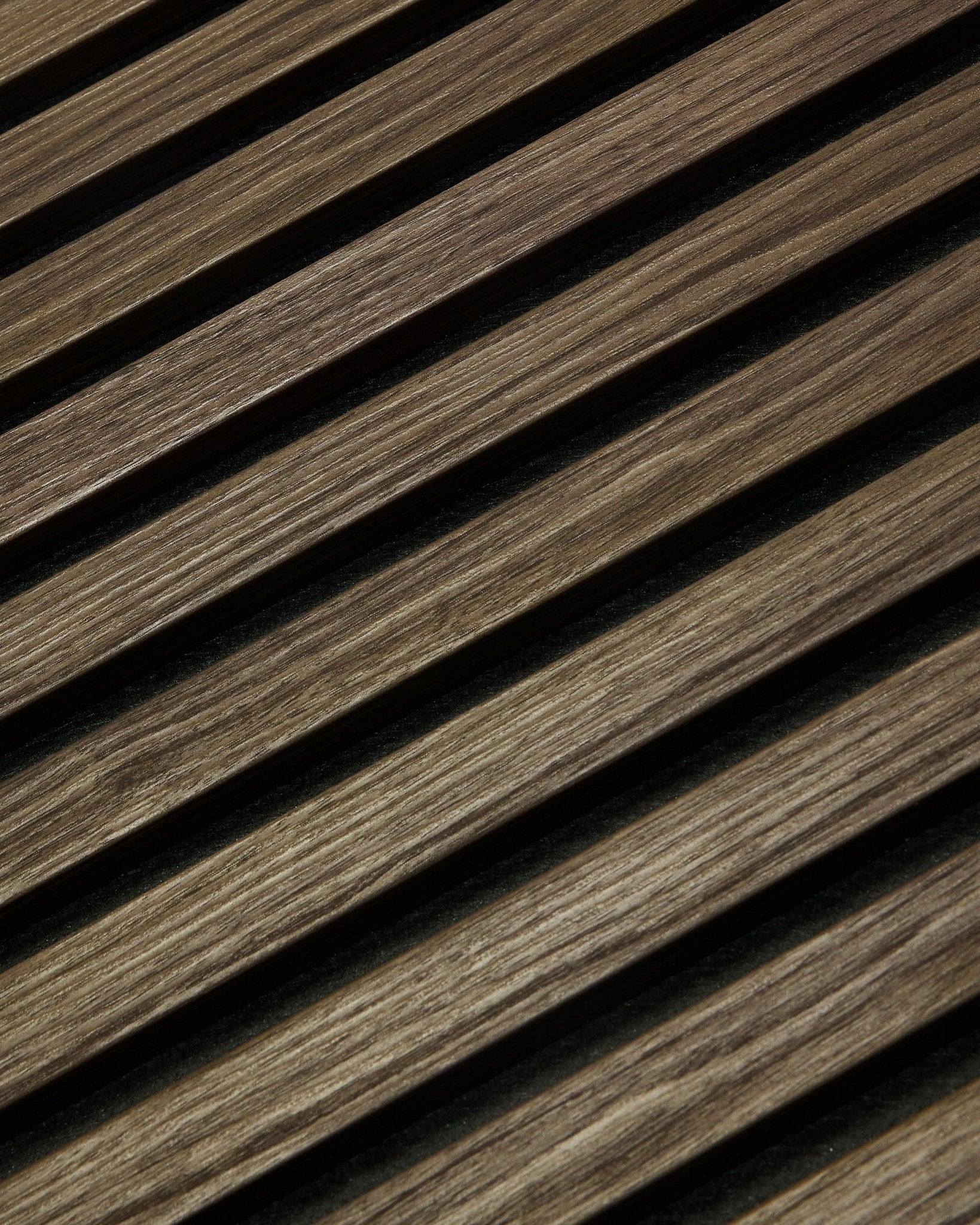 Close-up van WoodUpp Essential Akupanel in Black Oak, 240 x 60 cm, met diagonale houten latten met zichtbare nerf, ontworpen voor een betere akoestiek.