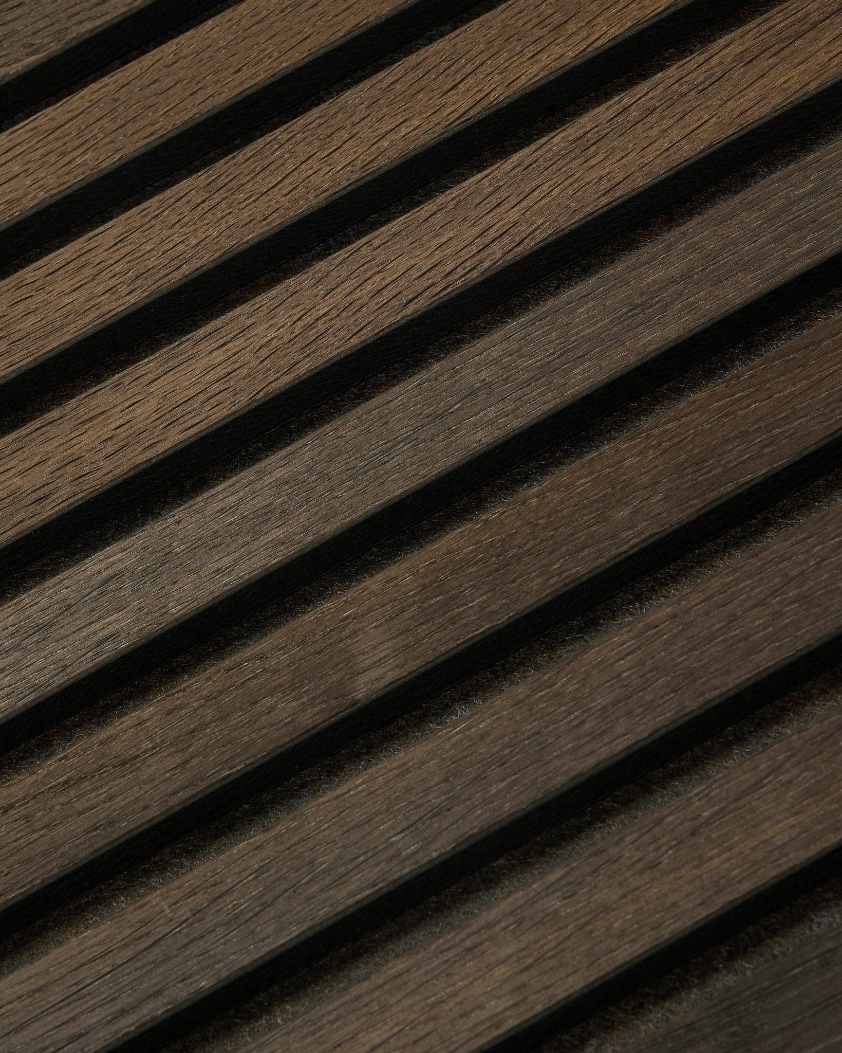 Close-up van Tonal Akupanel Akoestisch paneel in Smoked Oak (240 x 60 cm) van WoodUpp, met diagonale, getextureerde Nordic latten in een Scandinavisch design.
