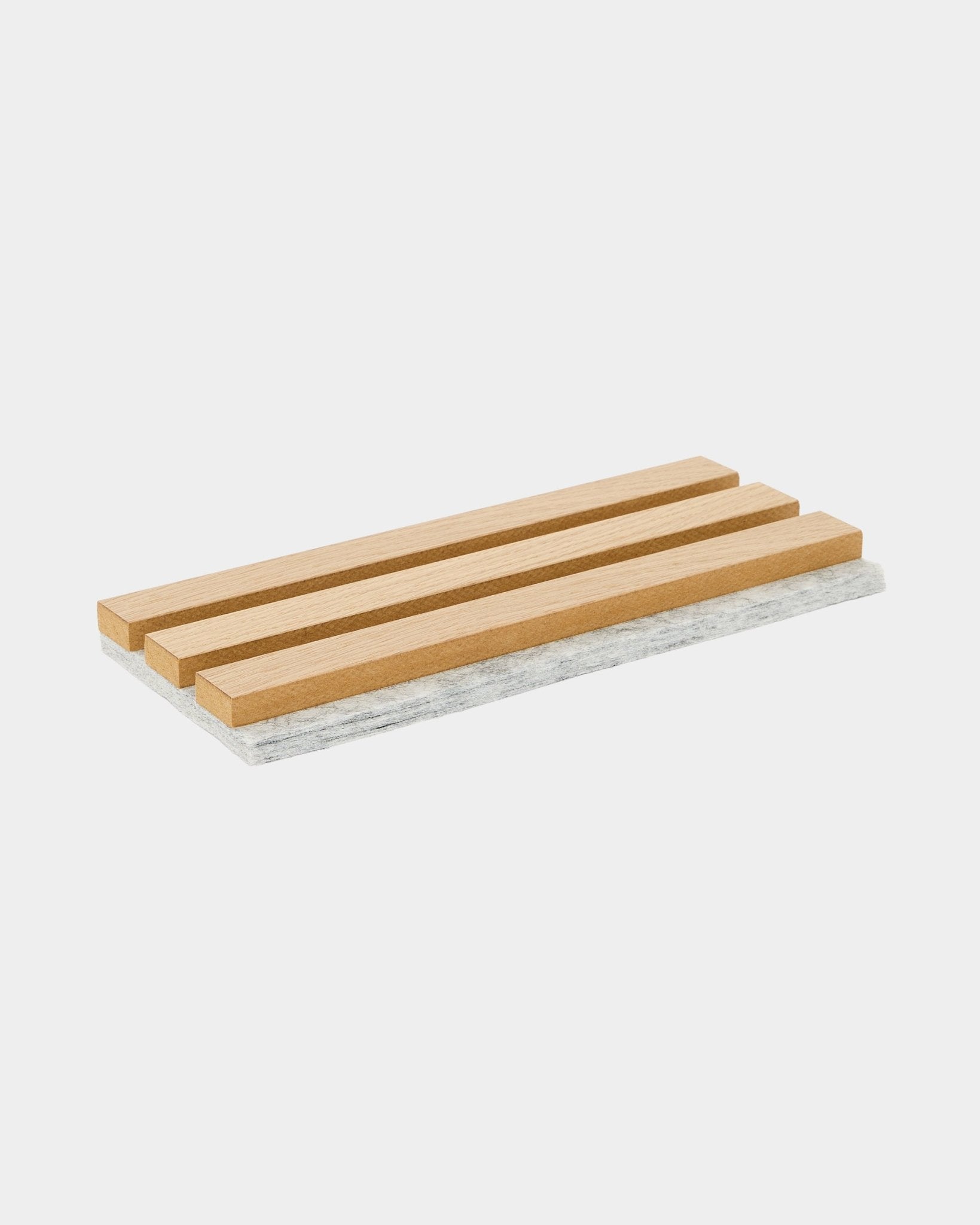 WoodUpp Akupanel onderzetterstaal met klassieke eikenhouten latten en een grijze vilten achterkant, ontworpen om oppervlakken te beschermen en het akoestische materiaal in Scandinavische stijl te laten zien.