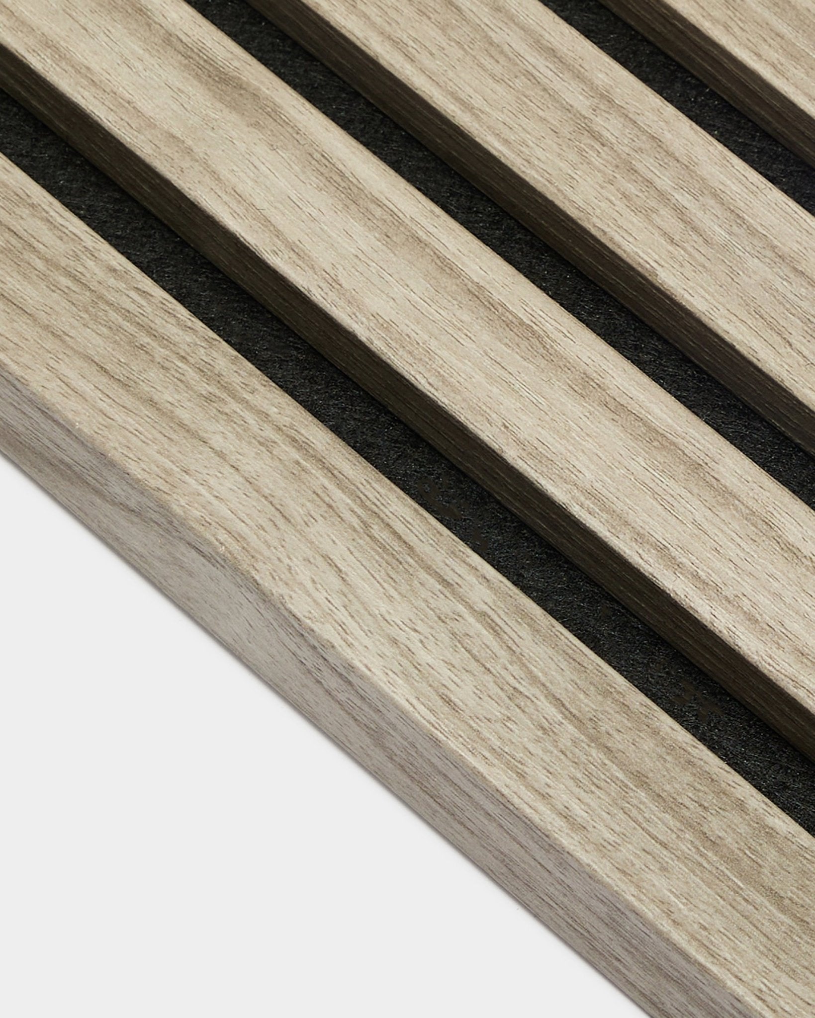 Close-up van WoodUpp Akupanel End Lamella in Weathered Oak, 2,2 cm—lichte akoestische latten van Nordic oak met black vilten achterkant op een witte achtergrond.