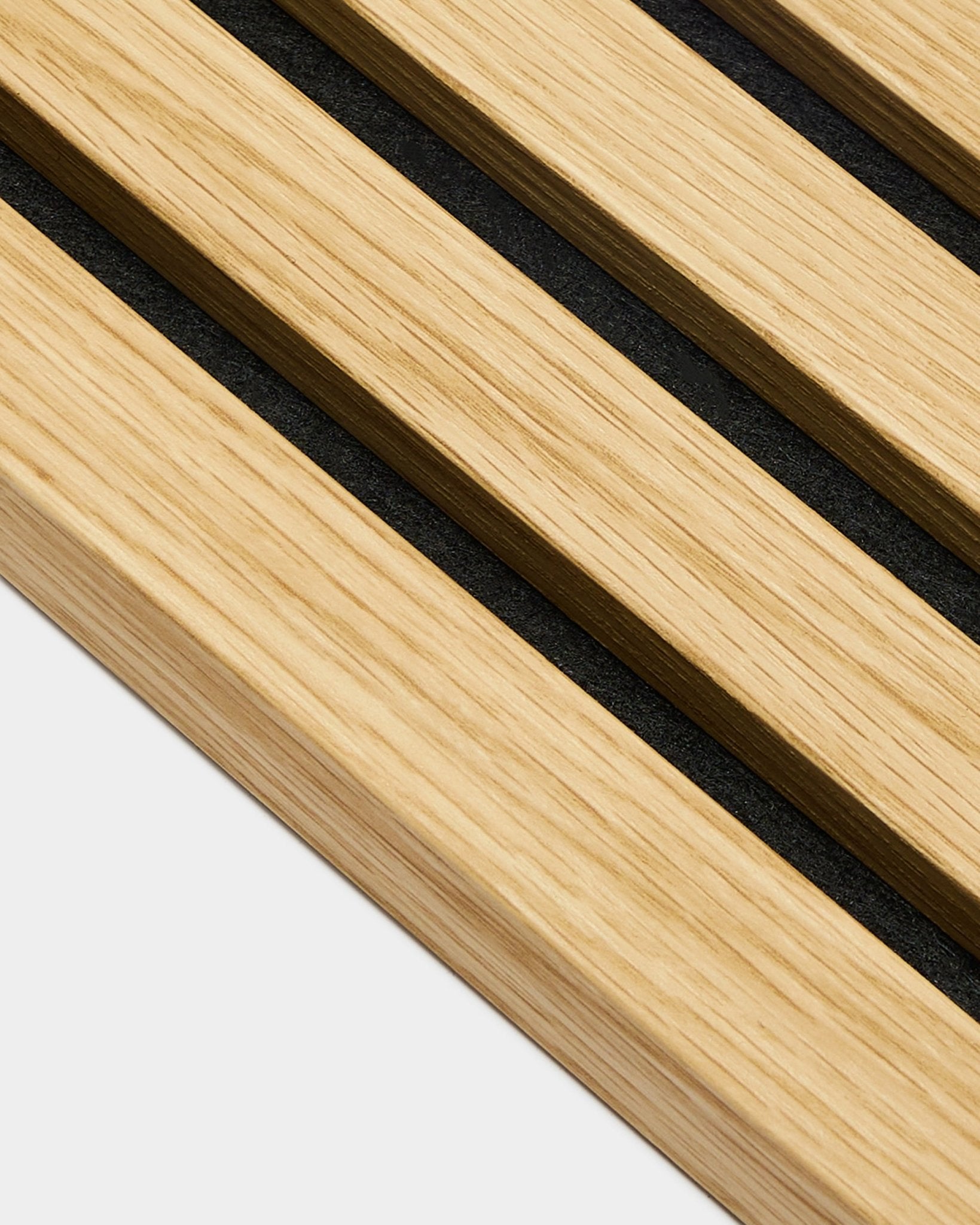 Close-up van WoodUpp Akupanel eindlamel in Southern Oak, met latten van 2,2 cm breed en tussenruimtes van black, diagonaal geplaatst op een lichte grey achtergrond.