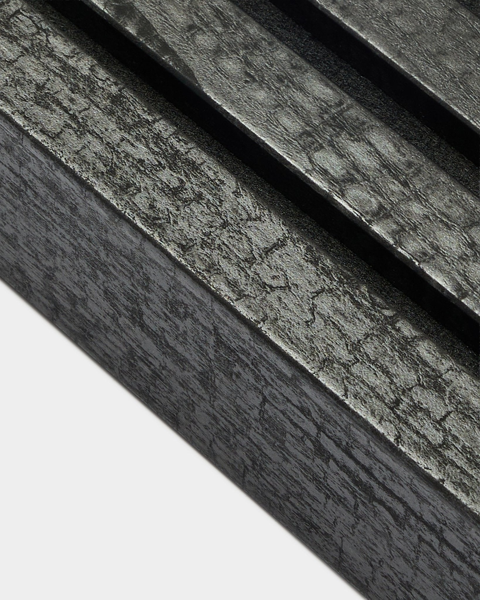 Close-up van de WoodUpp Akupanel eindlamel in Charcoal, 6,7 cm breed, met parallelle akoestische latten en een kenmerkende houtnerfstructuur.
