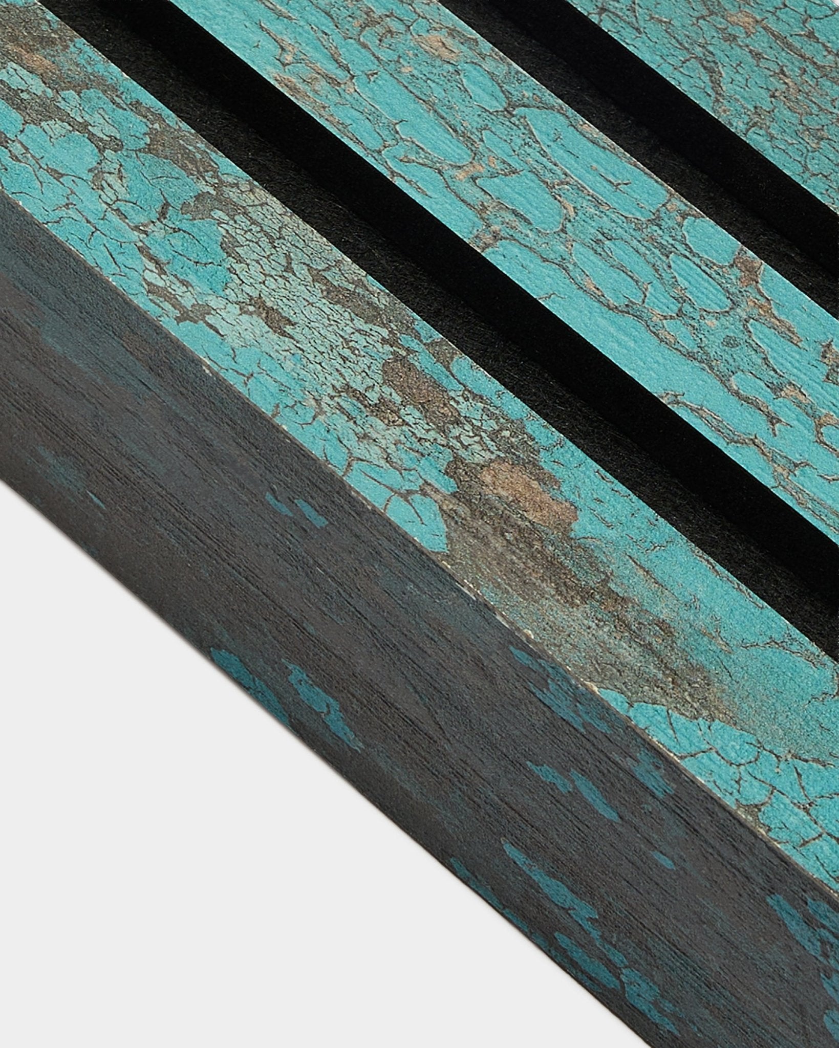Close-up van WoodUpp Akupanel eindlamel in Oxide Blue, 6,7 cm breed, met gebarsten blauwe verf en black groeven op een rustiek Akoestisch paneel-oppervlak.