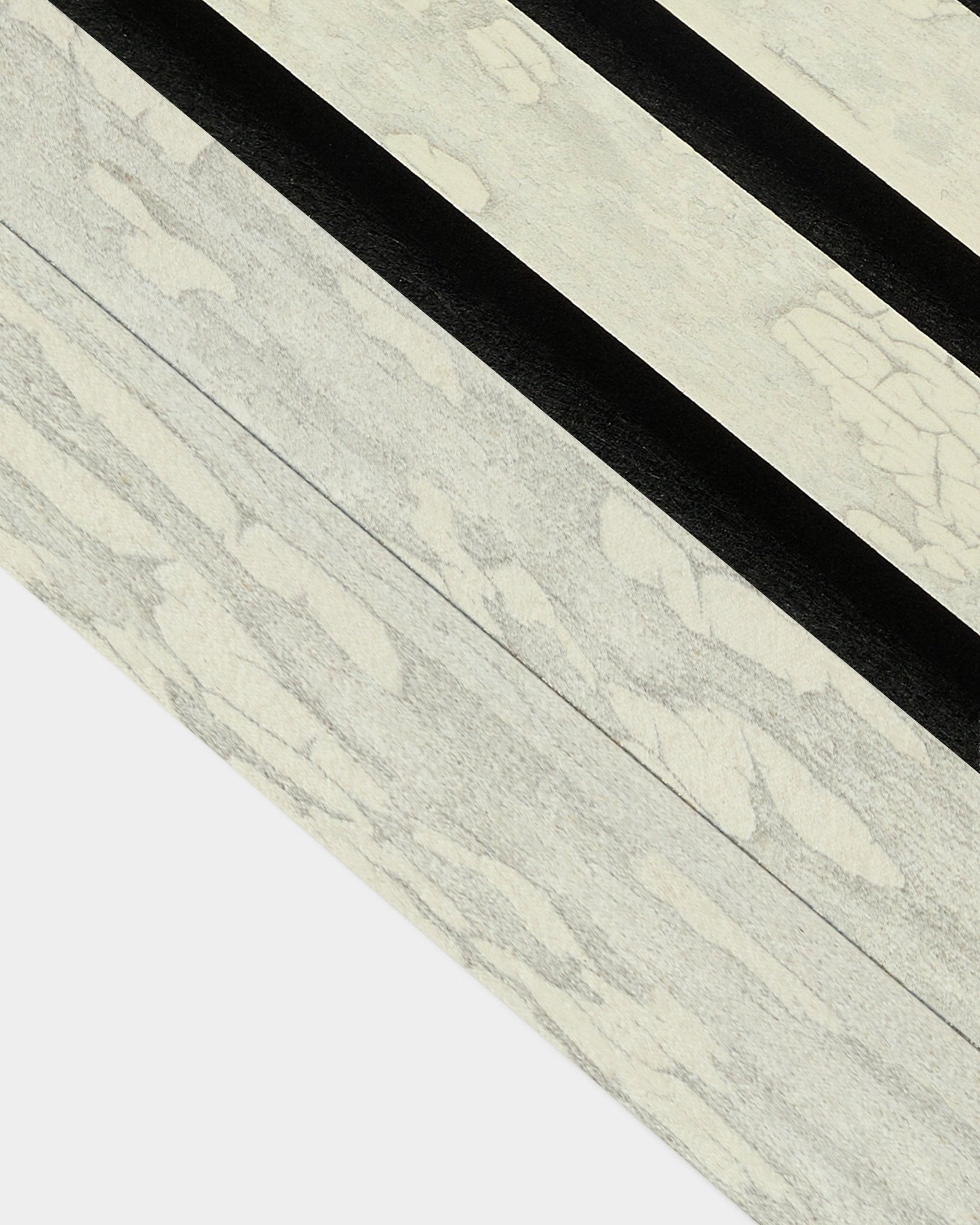 Close-up van de Oxide White eindlamel (6,7 cm) van WoodUpp voor installatie met Akupanel Akoestisch paneel, met uitgesproken diagonale black-patronen in een Scandinavisch design.