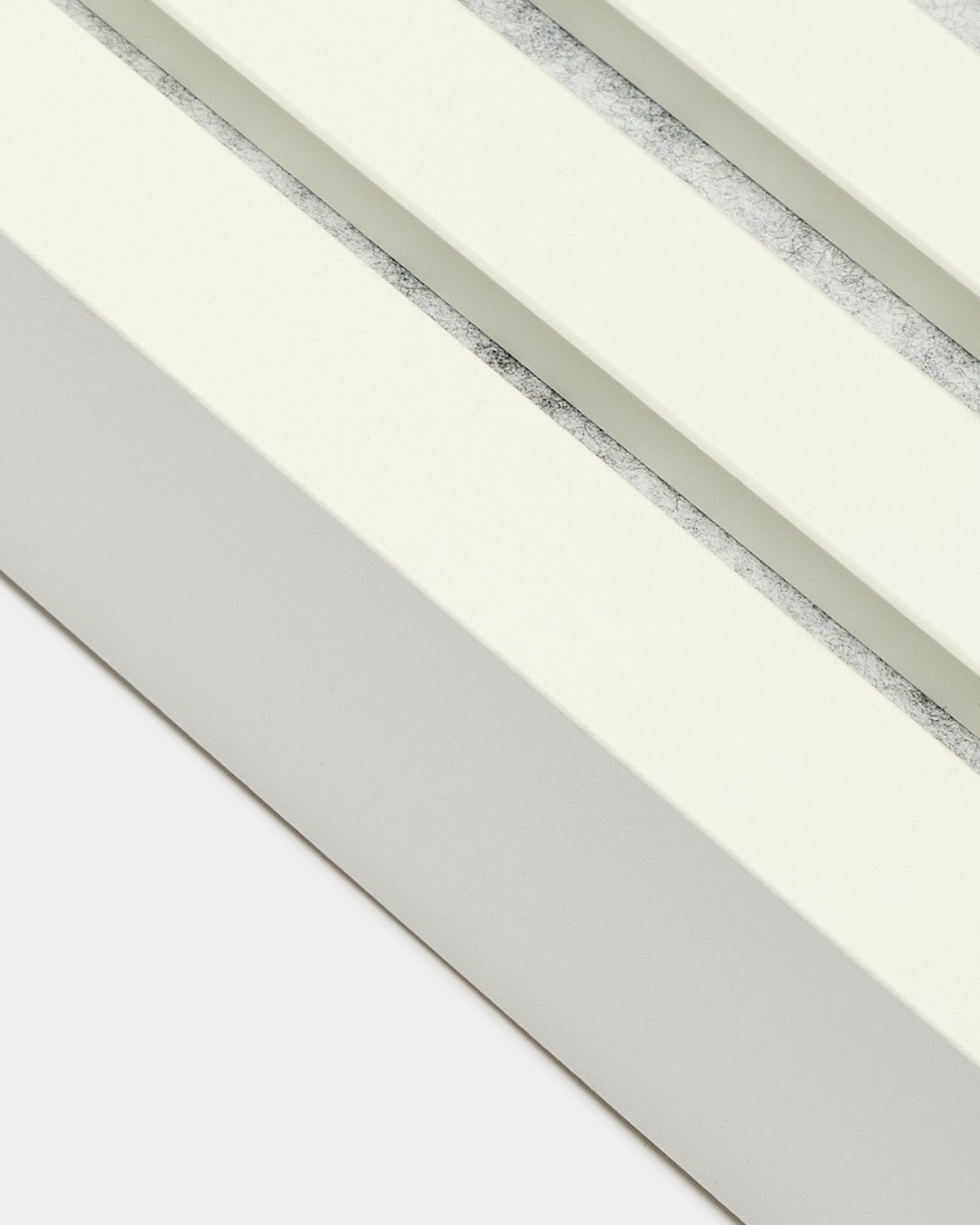 Close-up van WoodUpp eindlamel in Snow, 6,7 cm breed, met MDF-frame, dubbele groeven en een afwerking met textuur in grey voor Akupanel Akoestisch paneel installatie.