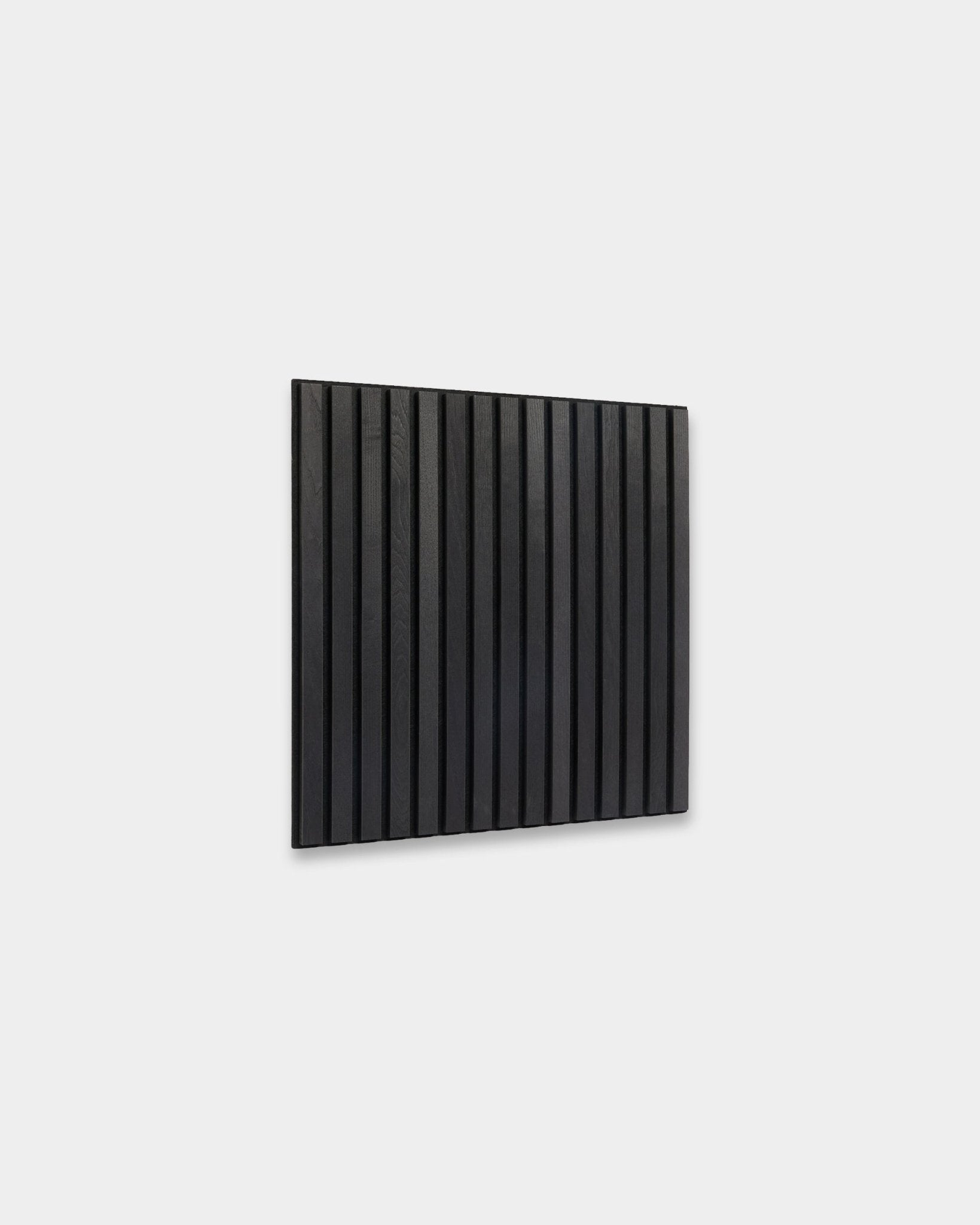 WoodUpp Akupixel Black Ash Akoestisch paneel (60x60 cm) met vertical houten latten, gemonteerd op een lichtgrijze muur, laat minimalistisch Scandinavisch design zien.