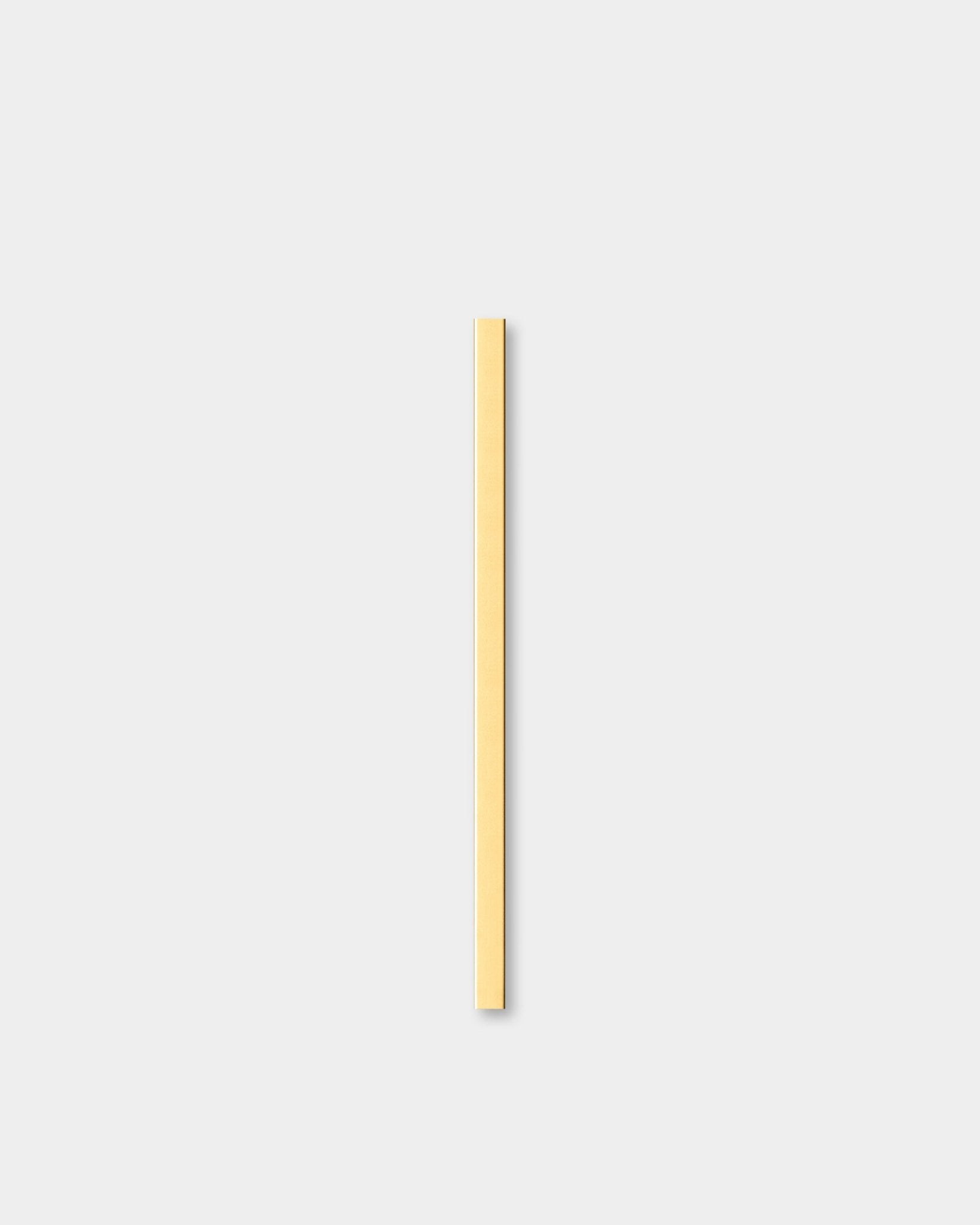 Le Liva | Cover en brass, 60 cm de WoodUpp, un Panneau acoustique, est présenté à la verticale sur un fond gris clair, à côté d’une moulure murale décorative.