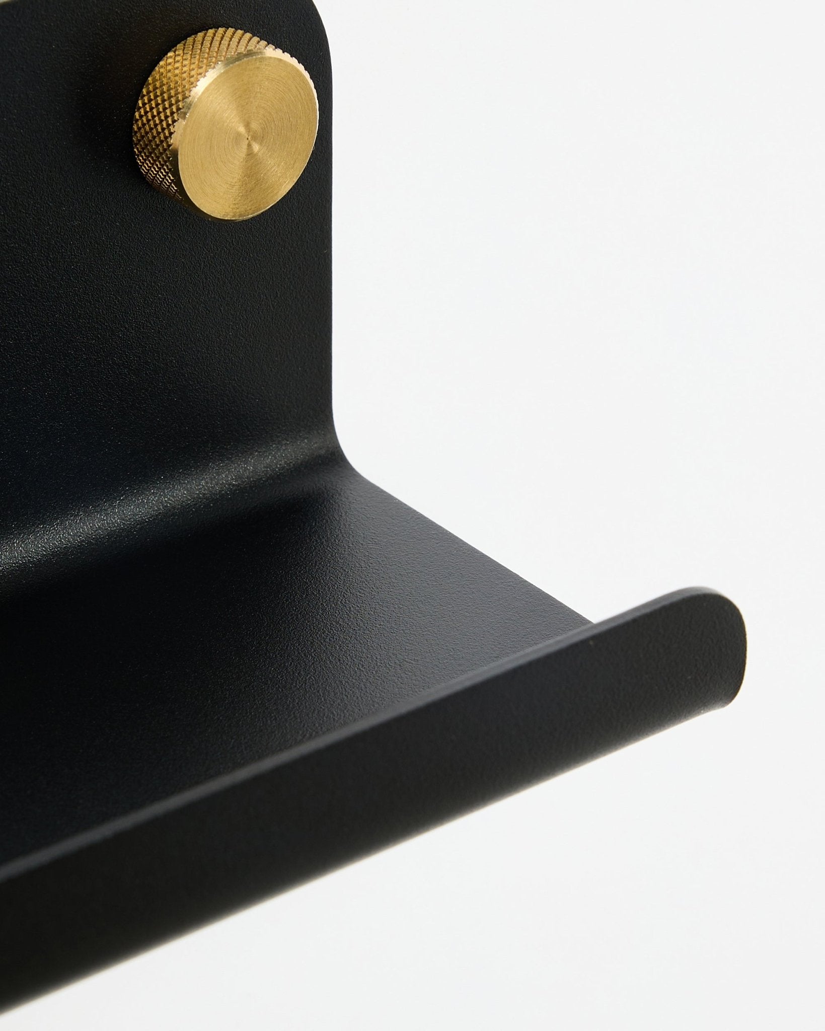 Close-up van de WoodUpp Norr Narrow Shelf in black, 75.9 cm, met een goudkleurige knop met textuur, getoond tegen een witte achtergrond.