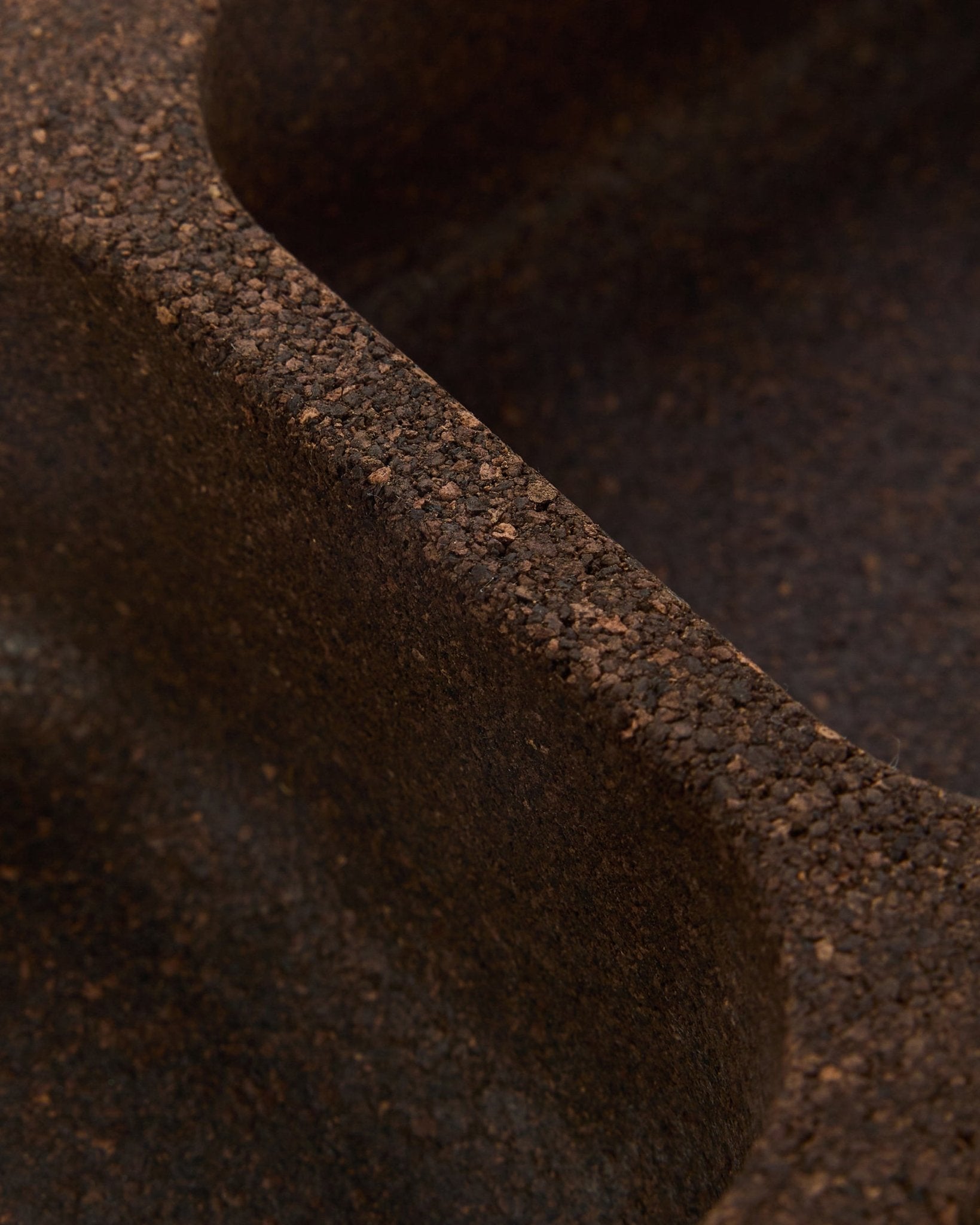 Close-up van het WoodUpp Norr Key Tray accessoire in gerookt kurk (35,9 cm), met een oppervlak van brown textuur, vloeiende gebogen lijnen en Scandinavisch design.