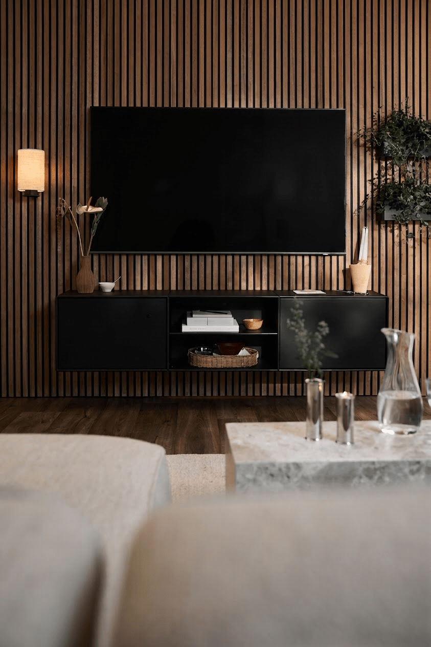 Salon moderne avec un meuble TV WoodUpp Arka noir, un mur à lattes Akupanel, des touches minimalistes et un canapé clair accompagné dune table basse.
