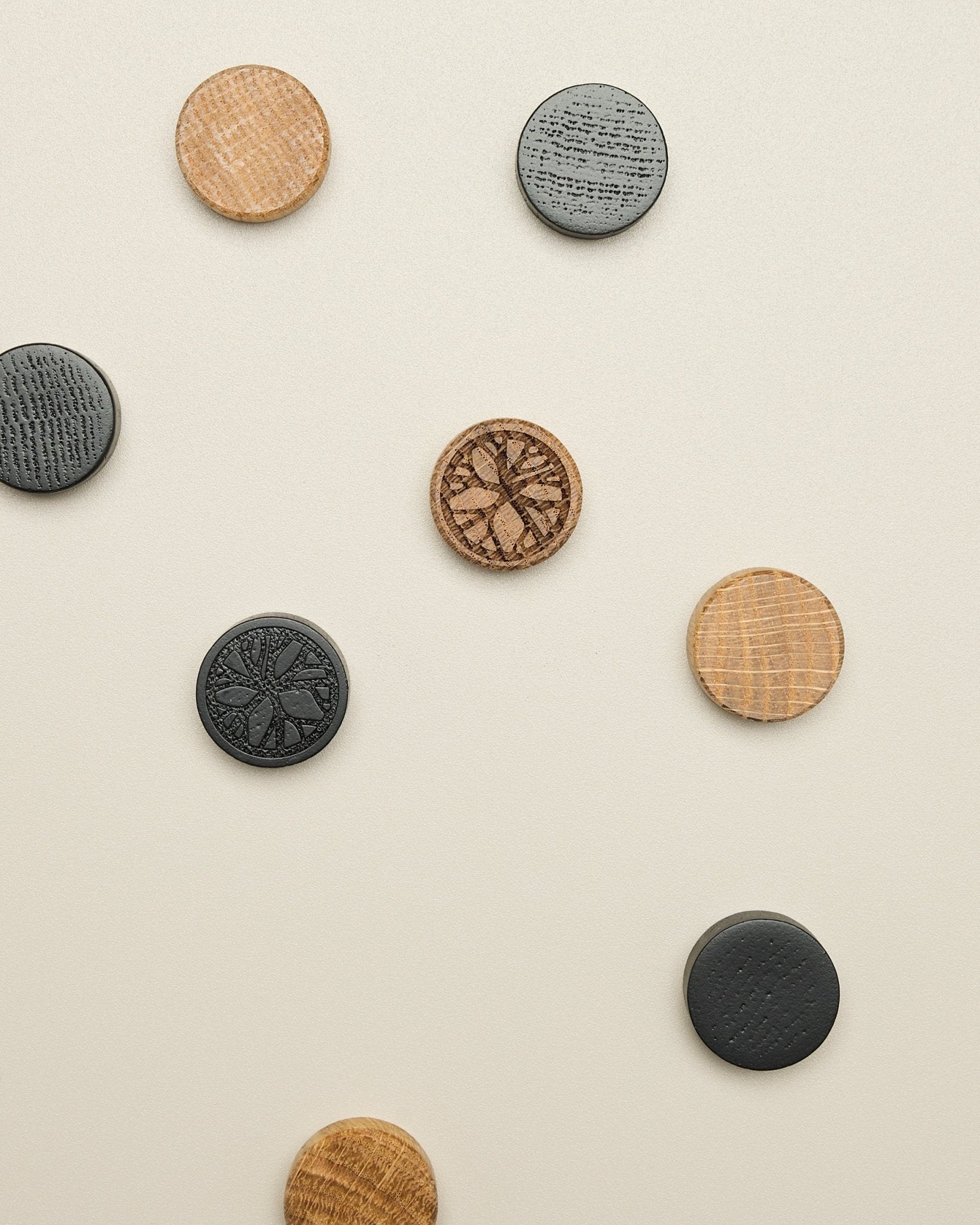 De Norr magneetset van WoodUpp bevat vier schijven met een natural oak en black patroon, netjes geplaatst op een licht beige oppervlak; accessoire voor Akupanel.