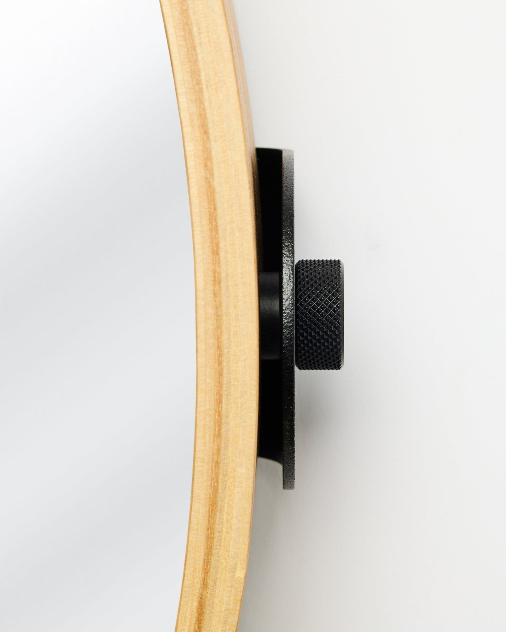 Close-up zijaanzicht van de WoodUpp Linn | Mirror in Natural Oak, met een rond frame van eikenhout en een black metalen knop, accessoire voor akoestische houten panelen.