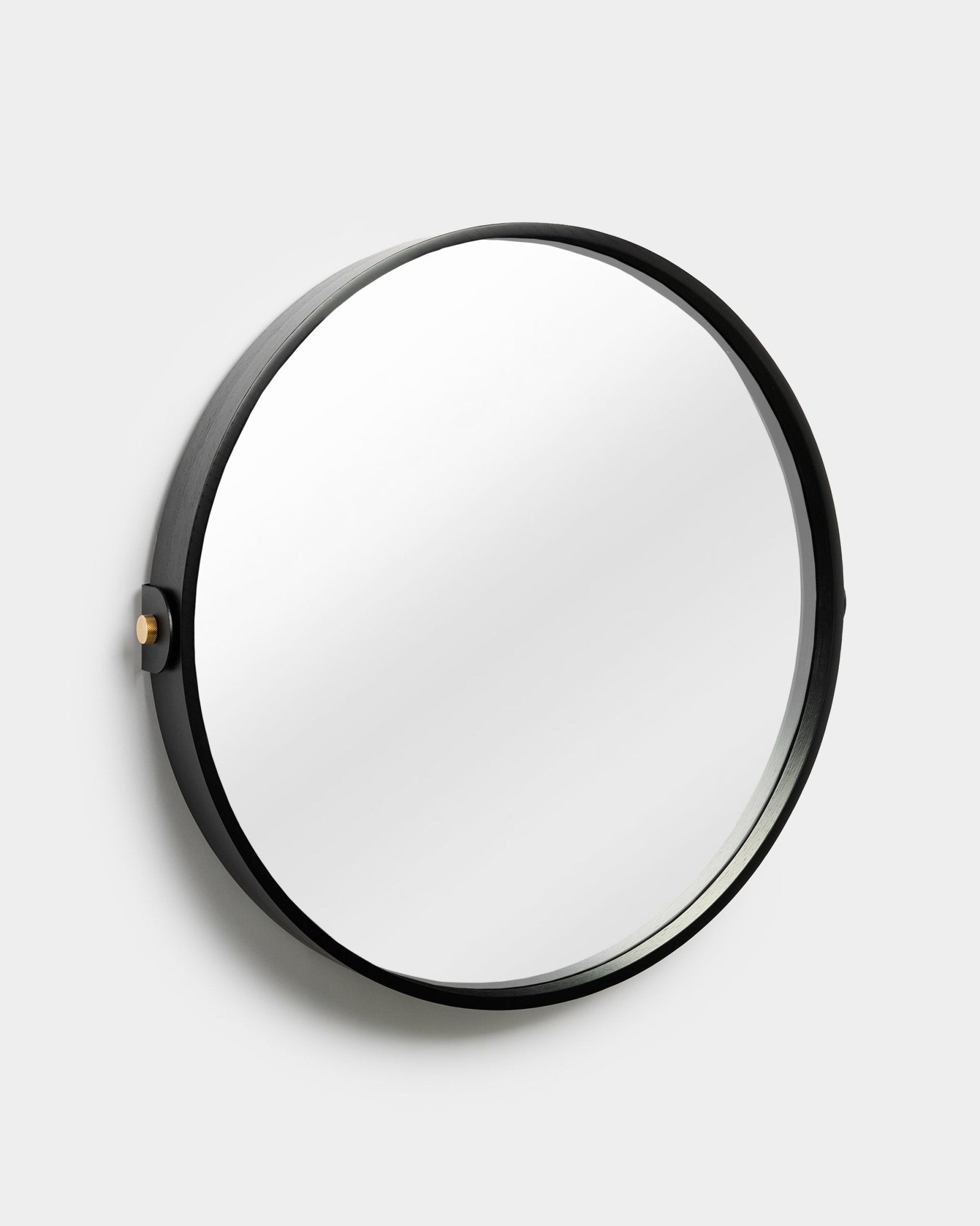 WoodUpp Linn spiegel in Black Oak, met een ronde verstelbare lijst en zijknop, afgebeeld tegen een effen lichtgrijze achtergrond.