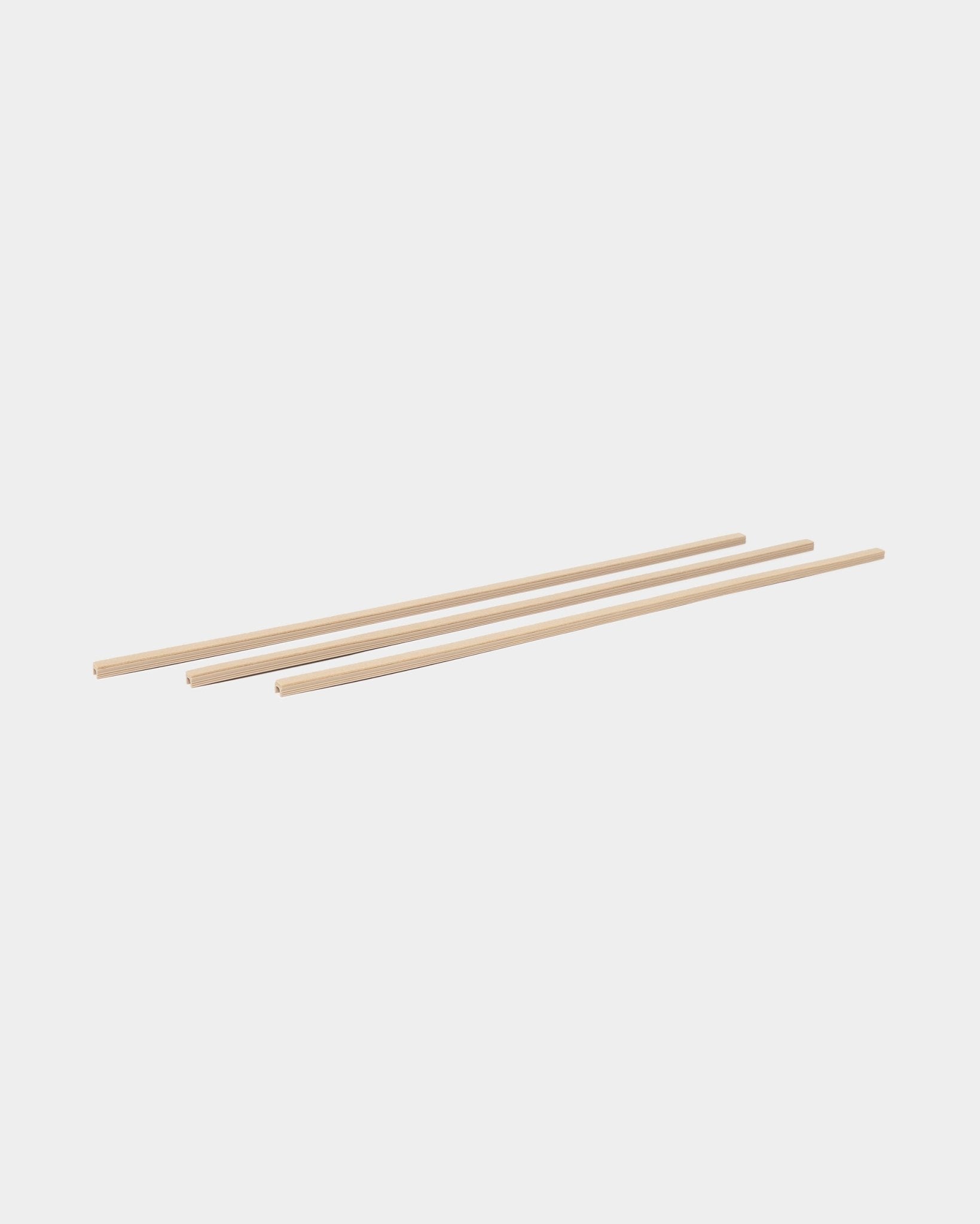 Drie beige Dupps Pop-on Cable Covers (3 stuks) van WoodUpp, onderdeel van de CREATE accessoirecollectie, parallel gerangschikt op een witte achtergrond.