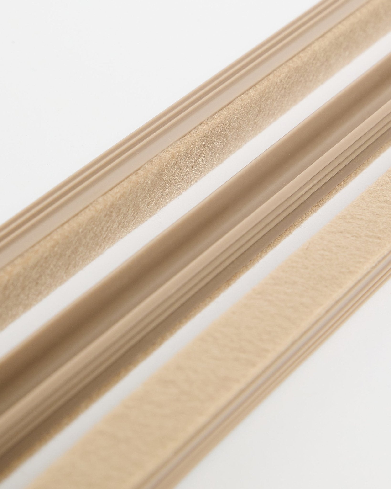 Cache-câbles Pop-on WoodUpp Beige Dupps (lot de 3), avec texture en feutre et dos adhésif, présentés sur une surface blanche pour organiser les câbles.