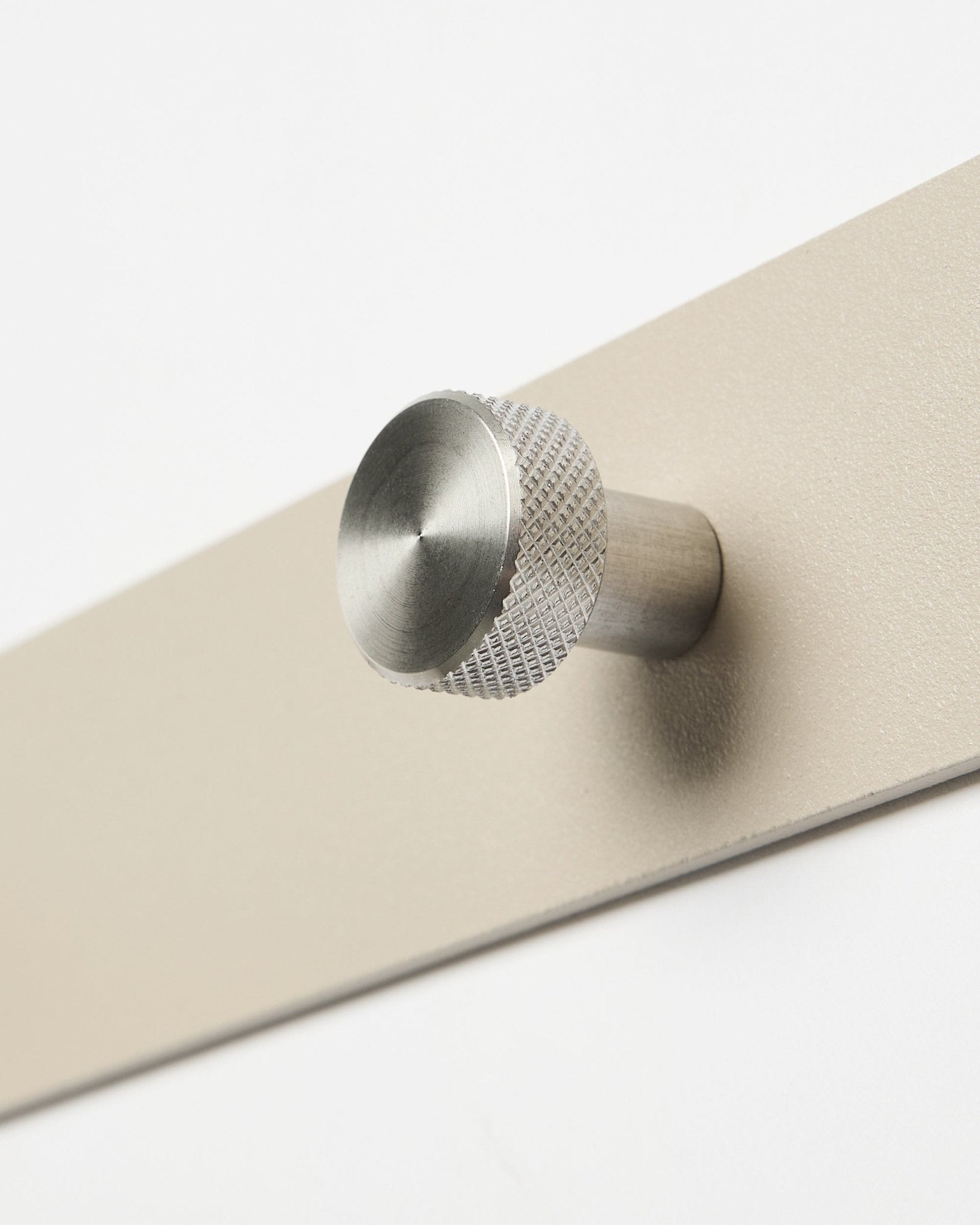 Close-up van de WoodUpp Norr kapstok in beige en roestvrij steel, X7, ontworpen als accessoire voor Akupanel akoestische houten panelen of organisatie in de hal.