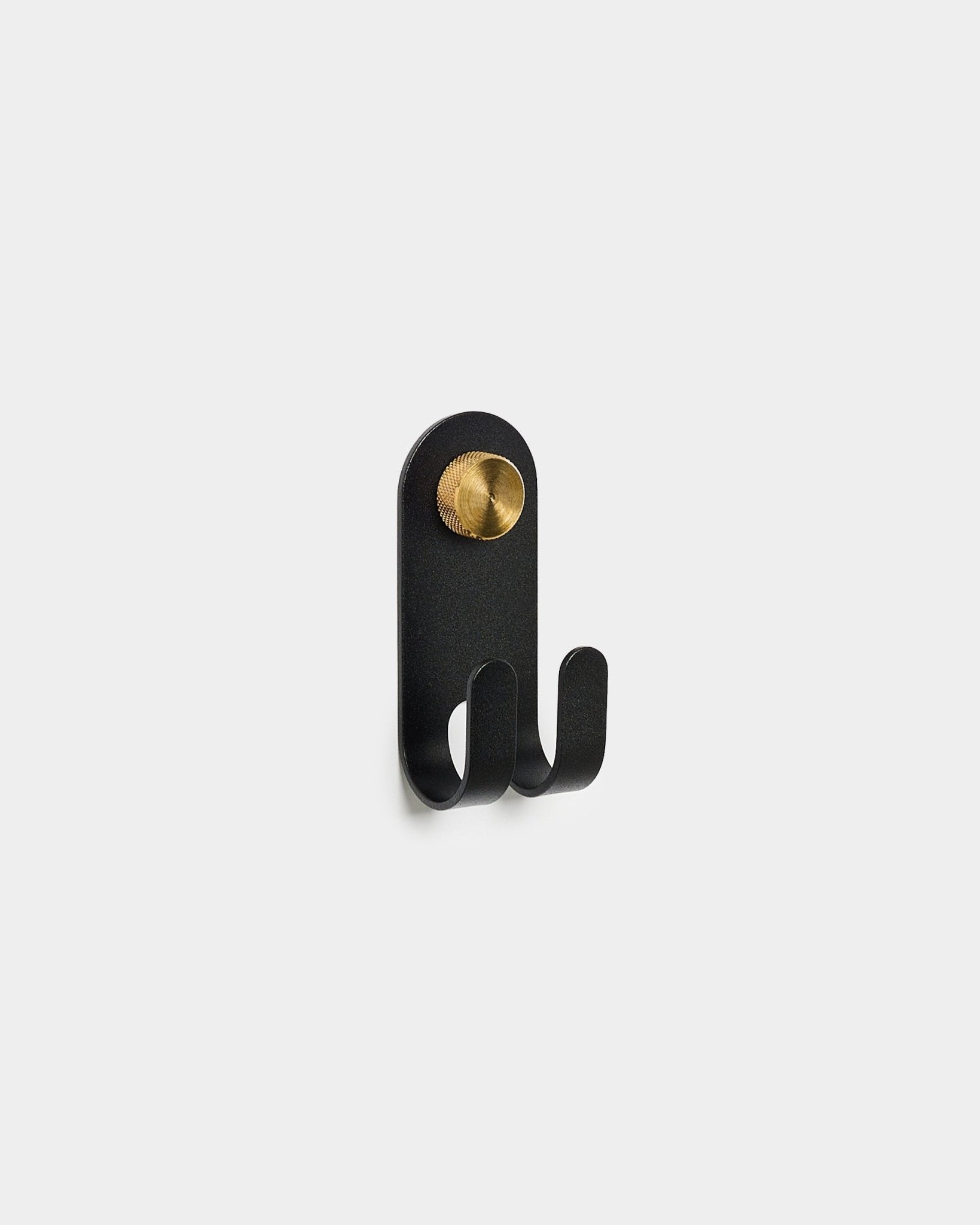 WoodUpp Norr Double Hanger in black, met twee haken en een rond brass accent, weergegeven op een effen witte achtergrond.