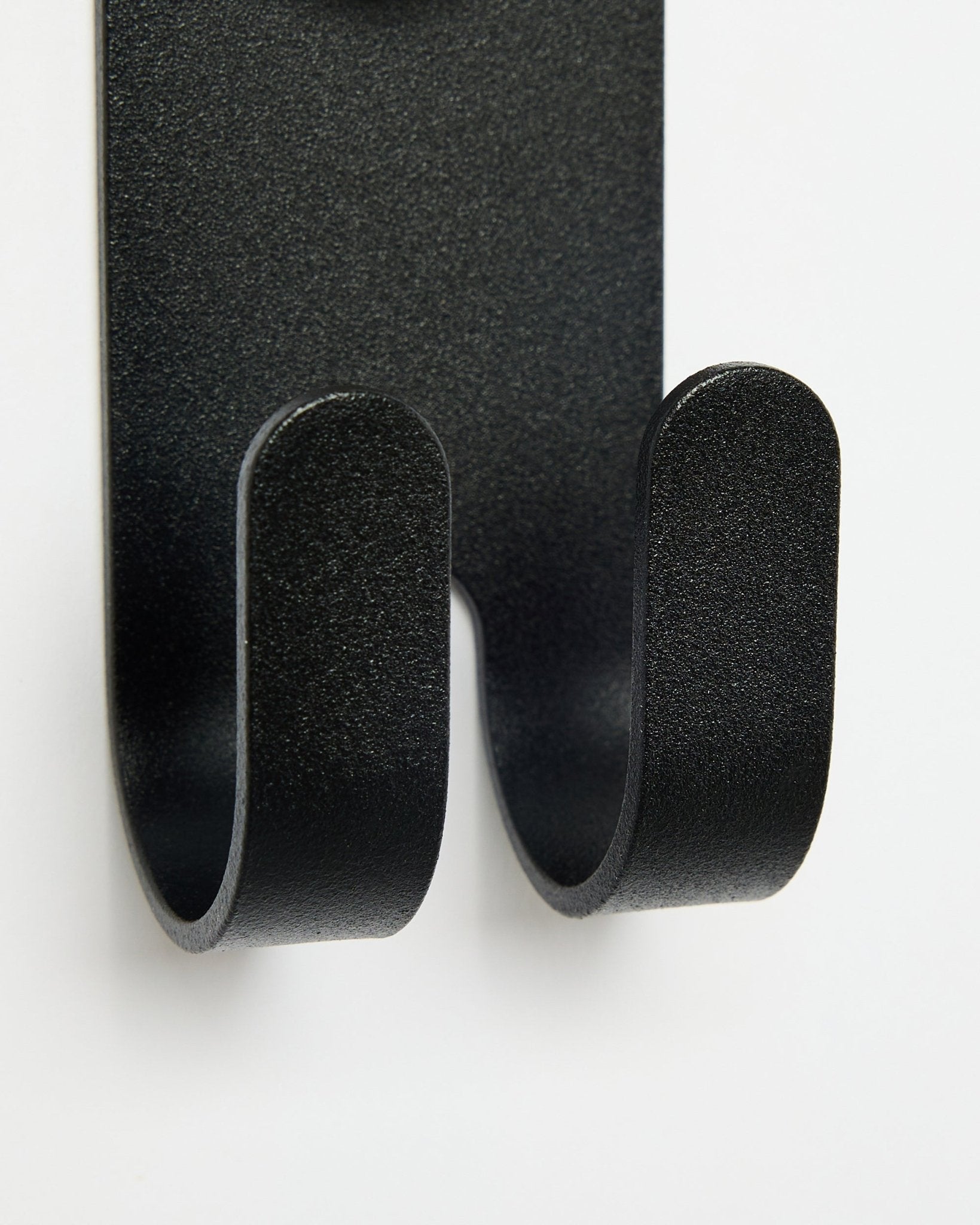 Close-up van de Norr Double Hanger in black van WoodUpp, met dubbele haken ontworpen voor Akupanel accessoires tegen een witte achtergrond.