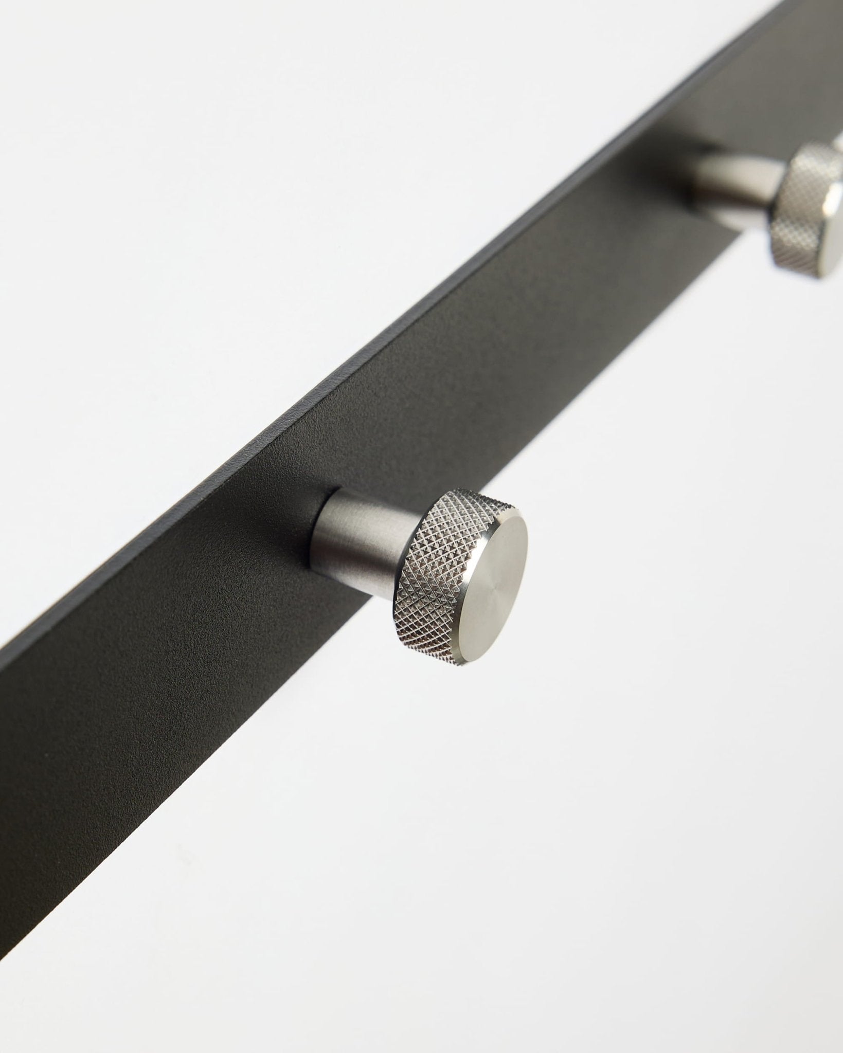 Close-up van Norr | Coat Hook Rack / X5 van WoodUpp in black en roestvrij steel, ontworpen als accessoire voor Akupanel akoestische panelen of gebruik in de hal.
