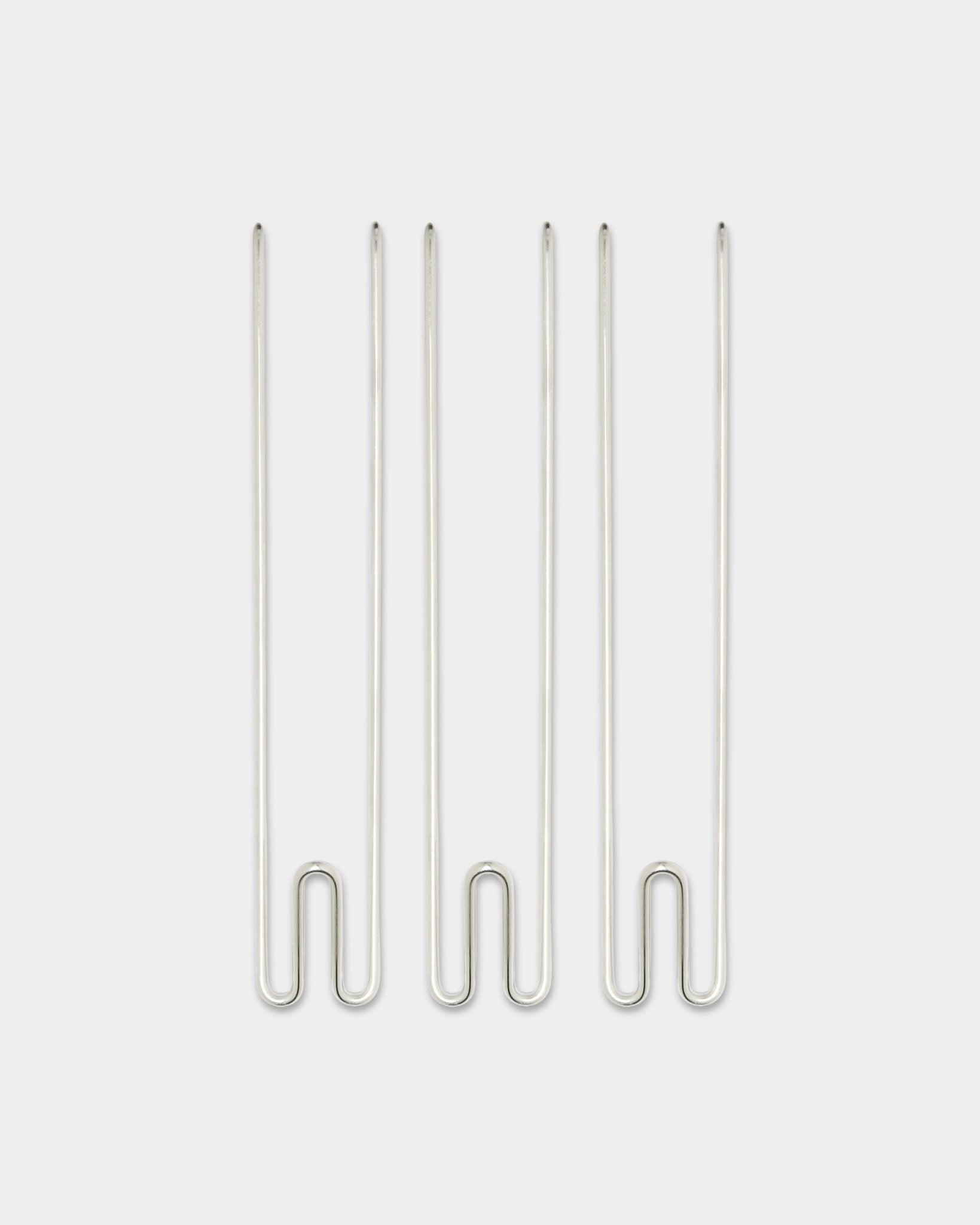 Drie Alva Wire Hook / BM1 accessoires van WoodUpp, lange roestvrijstalen steel haken verticaal gerangschikt op een effen witte achtergrond.