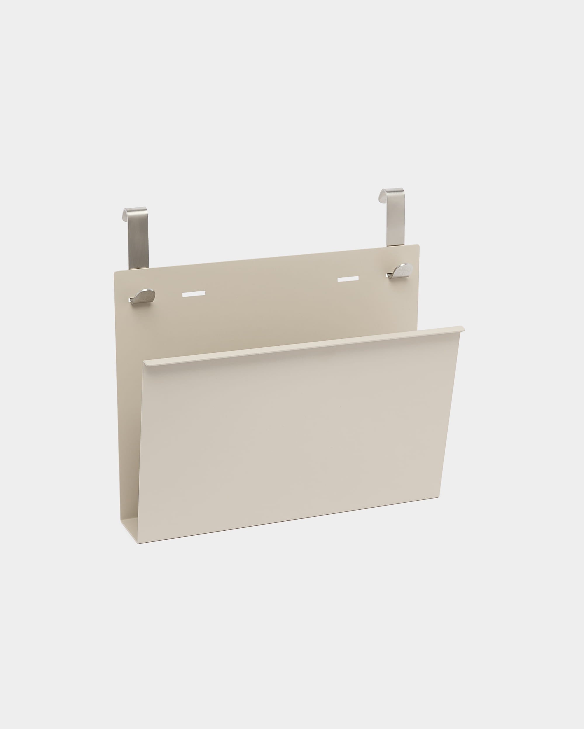 Nell Magazine Storage van WoodUpp is een beige gepoedercoate steel houder met twee zilveren haken om aan Nordic akoestische room dividers of scheidingswanden te hangen.