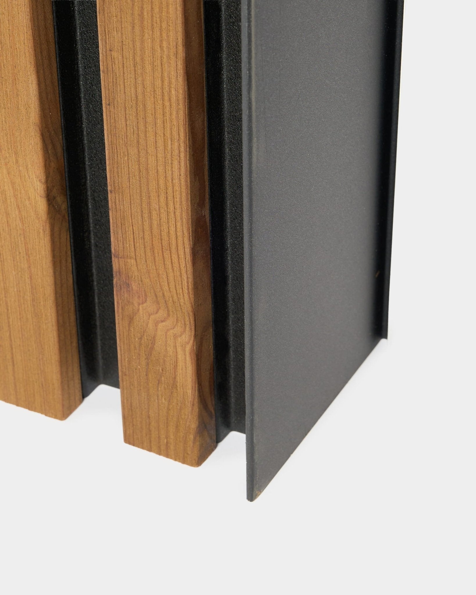 Gros plan sur un panneau de façade WoodUpp Aluwood, 240 cm, avec des lattes en bois verticales et un profilé en aluminium thermolaqué foncé pour une installation en extérieur.