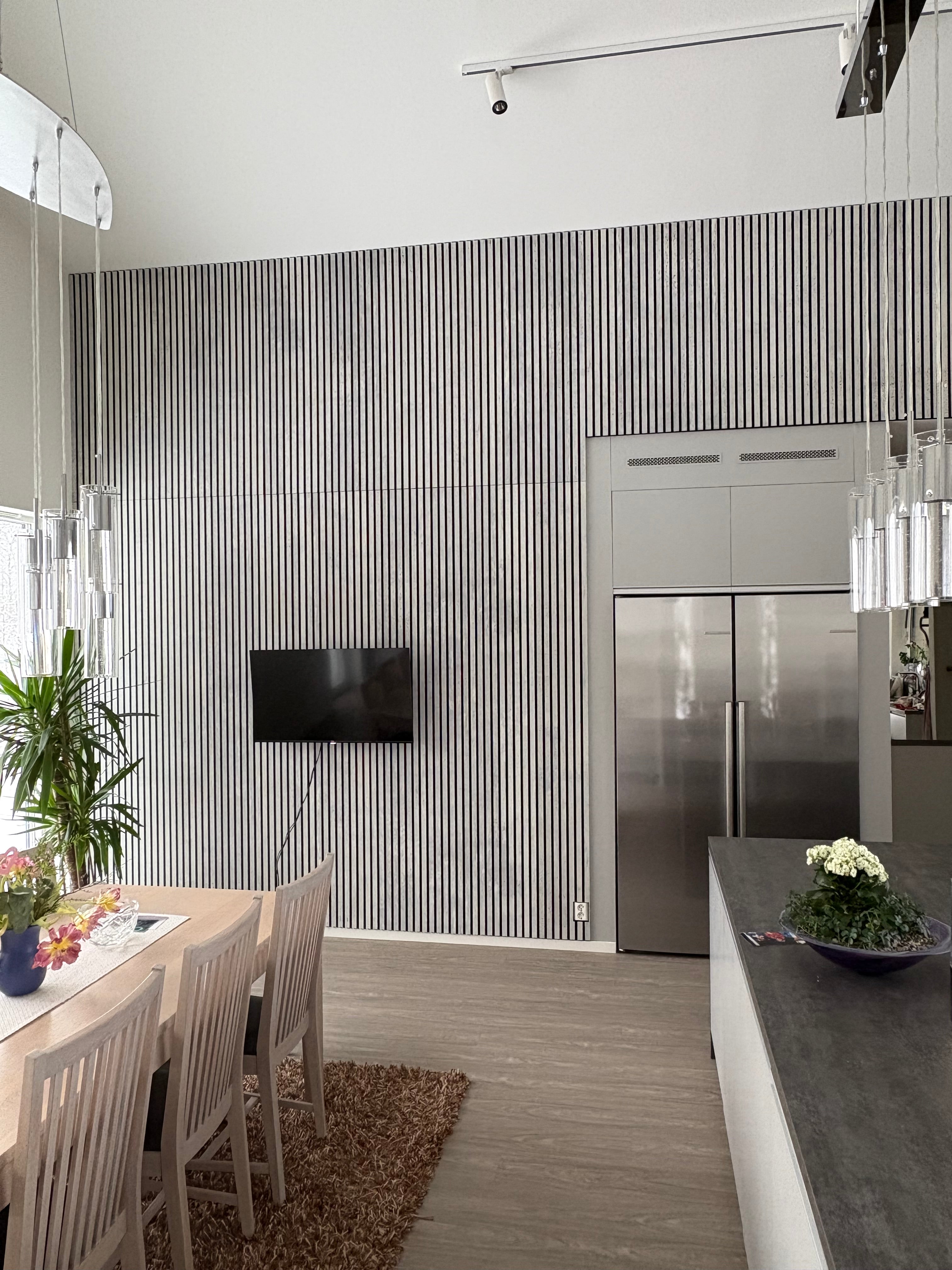 Akupanel white acoustic slat panels with black backing on kitchen wall beside stainless fridge