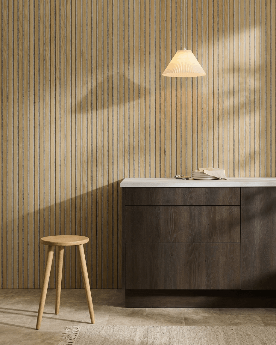 Minimalistisch Scandinavisch interieur met een WoodUpp Akupanel Akoestisch paneel in Classic Oak met Grey Felt, gecombineerd met een houten kruk, donkere kast en wit aanrechtblad.