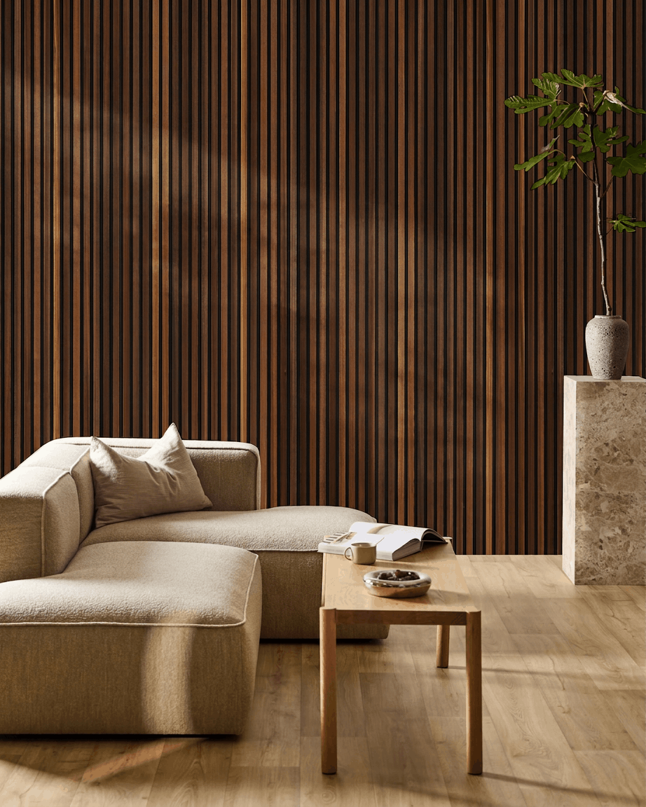 Minimalistische woonkamer met een beige bank, salontafel met een open boek, een hoge plant en een WoodUpp Akupanel akoestisch houten paneel in smoked larch aan de muur.